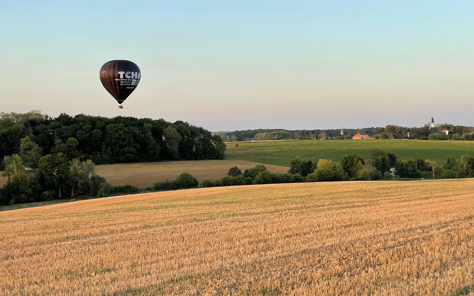 Montgolfière dans le ciel au dessus d'un champ